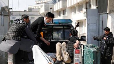 Men carry an injured person to the hospital after attacks in Kabul, Afghanistan. Reuters