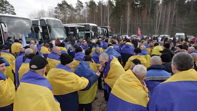 Wrapped in their national flag, freed Ukrainian prisoners of war gather after one of the swaps this week. Reuters