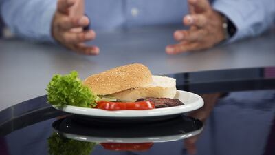 The world's first beef burger created from stem cells harvested from a living cow sits in front of scientist Mark Post. Simon Dawson / Bloomberg