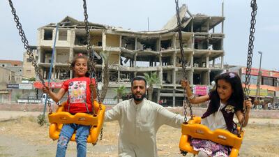 Girls ride on swings near a damaged building during the first day of the Muslim holiday of Eid in Raqqa, Syria. Reuters