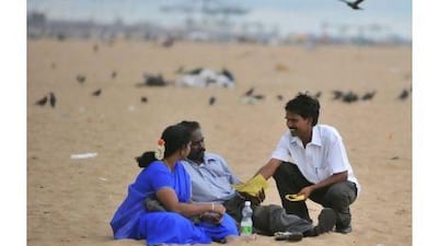 Kumar Sri Sri, right, founder of the All India Lovers Party, distributes campaign leaflets on Marina Beach in Chennai.