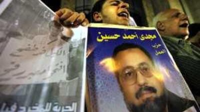 A protester holds up signs calling for the release of the activists Philip Rizk, left, and Magdi Hussein, who are being held by Egypt's security forces, at a demonstration in support of detainees this week.