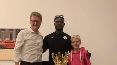 Nick March, Assistant Editor-in-Chief at The National, with his son Robert, right, and Micah Richards, during a home visit in Abu Dhabi with the Premier League trophy. Courtesy Nick March