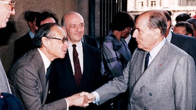 French President François Mitterrand shakes hands with Pei. AFP