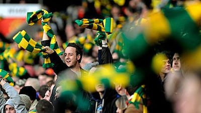 Manchester United fans wave yellow and green scarves during a league match last month.