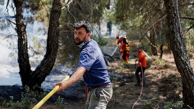 Martin de Valdeiglesias residents help Spain's Military Emergencies unit tackle the wildfire in wooded areas. Reuters