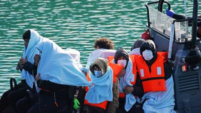 A group of people thought to be migrants are brought to England's southern coast at Dover, Kent, by members of the UK Border Force. Getty