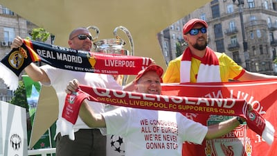 Liverpool fans pose in front of the UefaA Champions League trophy at the fan zone in Kiev. Sergei Supinsky / AFP