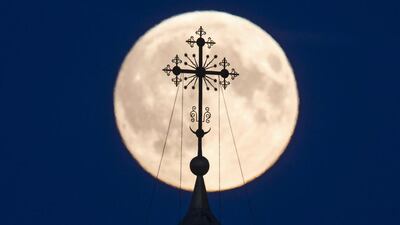 A cross atop of a local monastery is seen silhouetted against the moon in the settlement of Poschupovo in Ryazan region, Russia. Maxim Shemetov / Reuters
