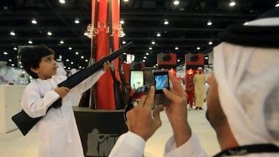A small boy poses with a rifle at Adihex.