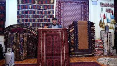 Abdul Wahab, a tribal carpet collector, displays a rug at his shop on Chicken Street in Kabul. AFP