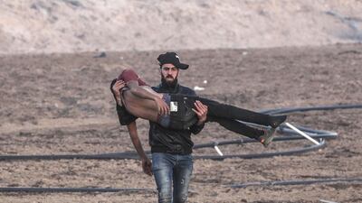 A Palestinian protester carries a wounded comrade during the clashes near the maritime border between Israel and Gaza Strip. EPA