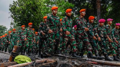 Military personnel on clear-up detail following a demonstration outside the Mobile Brigade police headquarter in Jakarta, Indonesia, on Saturday, August 30. Government buildings and police vehicles were set on fire during protests following the death of a taxi driver during an earlier protest against housing allowance for MPs. EPA
