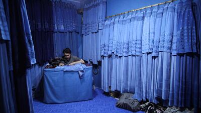 An Afghan tailor stitches burqas in a shop in the western city of Herat. AFP