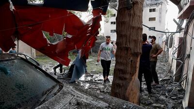 People inspect a destroyed car inside a house, following an Israeli airstrike on the upper floors of a commercial building in Gaza city. AP Photo