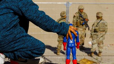 A migrant boy from Venezuela with a Captain America doll at the border between Mexico and the United States. Reuters