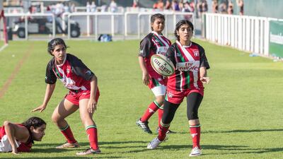Al Maha School girls team watch a ball bounce loose.