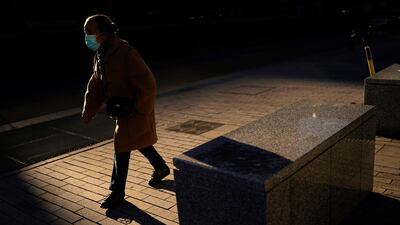 A woman, wearing a face mask to prevent the spread of the coronavirus, walks along the European quarter in Brussels. AP Photo