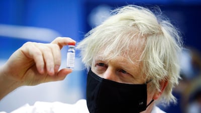 Britain's Prime Minister Boris Johnson holds a vial of an Oxford-AstraZeneca vaccine, during his visit to a vaccination centre at Cwmbran Stadium in south Wales. Reuters
