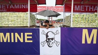 A police officer stands in front of a haul of drugs before a destruction ceremony to mark International Day against Drug Abuse and Illicit Trafficking, in Yangon, Myanmar on June 26. AFP
