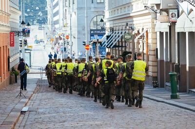 Military and police personnel walk around the area of the Finnish Presidential palace in Helsinki, hours ahead of the meeting between US President and his Russian counterpart. AFP