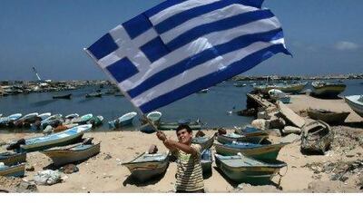 A Palestinian boy waves a Greek flag during a rally in Gaza City in support of the international Freedom Flotilla that is hoping to breach Israel's sea blockade on Gaza as it remained banned by Greece from setting sail yesterday. Mahmud Hams / AFP