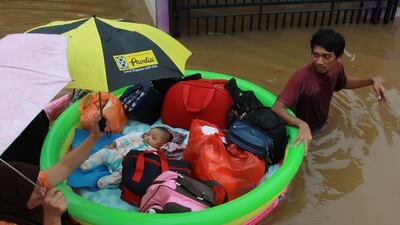A baby is evacuated by a rescue team using an inflatable boat after floods hit a residential area in Tangerang, near Jakarta, Indonesia. Reuters
