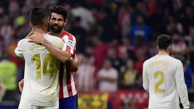 Atletico Madrid's Spanish forward Diego Costa (R) hugs Real Madrid's Brazilian midfielder Casemiro at the end of the Spanish league football match between Club Atletico de Madrid and Real Madrid CF at the Wanda Metropolitano stadium in Madrid on September 28, 2019. / AFP / JAVIER SORIANO