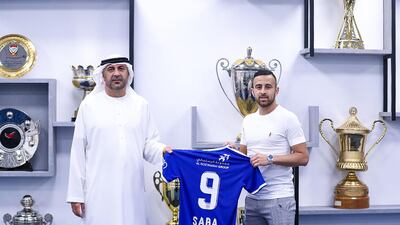 Israeli midfielder Diaa Saba poses with a club official after signing with UAE club Al Nasr. AFP