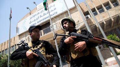 Security personnel gather outside Erbil governor's building after clearing it of gunmen. EPA