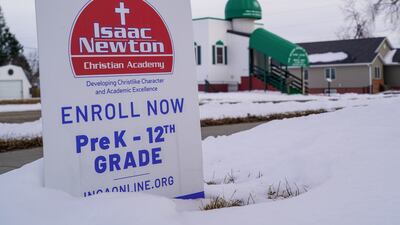 A sign for a Christian academy rests in front of the Mother Mosque of America.
