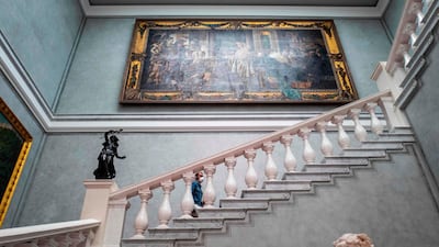 A visitor wearing a face mask climbs a flight of stairs at the Alte Nationalgalerie (Old National Gallery) museum in Berlin on May 12, 2020, after the museum reopened its doors to the public following a relaxation of lockdown restrictions. AFP