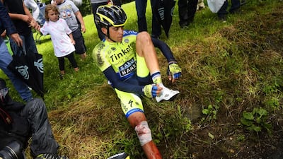 Spain's Alberto Contador sits after a fall during the 161.50km 10th stage of the Tour de France on July 14, 2014. Contador says he was trying to eat a nutrition bar when, with only one hand on the handlebars, he hit a pothole and lost control. Lionel Bonaventure / AFP