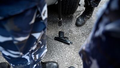 Members of the Lebanese security forces stand next to a toy gun that was used by depositors to take hostages. EPA