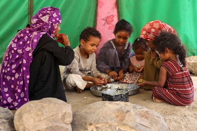 A displaced family share a meal in Yemen. AFP