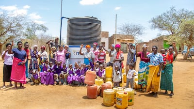 The Ikulumbutuni community poses at the Project Maji waterpoint. All photos: Project Maji