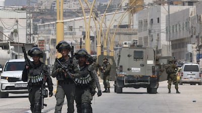 Israeli security forces block a road leading to the site of a reported attack, south of Hebron, in the occupied West Bank, on Monday. AFP