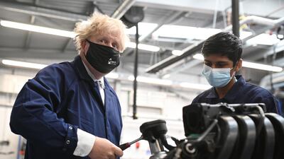Britain's Prime Minister Boris Johnson assists in an engine repair at an automotive shop during a visit to Kirklees College Springfield Sixth Form Centre in Dewsbury, northern England. AFP
