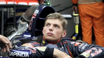 Toro Rosso team's young driver Max Verstappen of the Netherlands listens to a crew member in the pit ahead of the Formula One Japanese Grand Prix in Suzuka on October 2, 2014. AFP