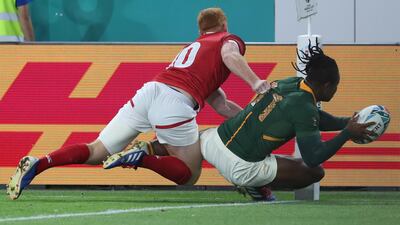 Peter Nelson of Canada cannot stop South Africa's S'Busiso Nkosi from scoring a try. EPA