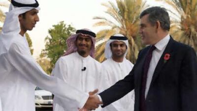 Britain's prime minister Gordon Brown, centre, with students in Abu Dhabi as part of the four-day trade visit to the Gulf.
