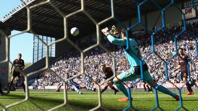 Callum McManaman of Wigan Athletic scores his team's third goal past Reading keeper Alex McCarthy during the English Championship match. Clive Brunskill / Getty Images