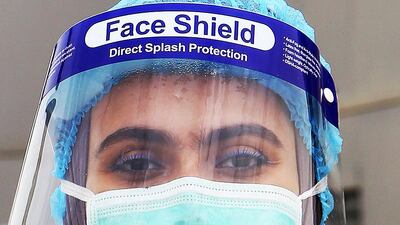 A Kuwaiti health ministry worker looks on before scanning returning expatriate workers from Egypt, Syria, and Lebanon upon their arrival at a containment and screening zone for COVID-19 coronavirus disease in Kuwait City on March 15, 2020. / AFP / YASSER AL-ZAYYAT