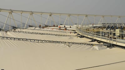 Technicians work on the special 'PTFE' roof that will protect spectators from the elements. AFP