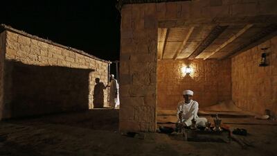 An Emirati man prepares coffee over a fire. Karim Sahib / AFP Photo