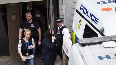 Police officers escort a woman to a police van after raiding a block of flats in Barking, east London on June 4, 2017. Hannah McKay / Reuters