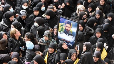 Lebanese women lift a picture of a fighter in the Shiite Hezbollah movement killed in Syria, during a funeral procession in a suburb of the Lebanese capital Beirut. AFP