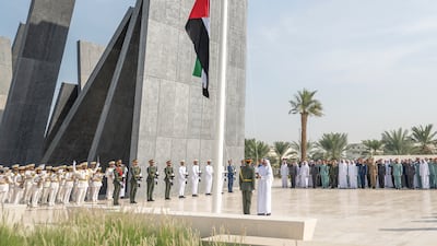 Sheikh Theyab bin Mohamed, chairman of the Office of Development and Martyrs Families Affairs at the Presidential Court, raises the UAE flag at Wahat Al Karama in Abu Dhabi. Photo: Abu Dhabi Media Office