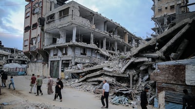 Palestinians walk between destroyed buildings during Eid Al Adha in Gaza City. Bloomberg