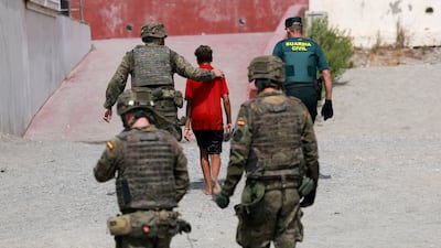 An unaccompanied migrant minor from Morocco is escorted by Spanish security forces in Ceuta, Spain. Reuters